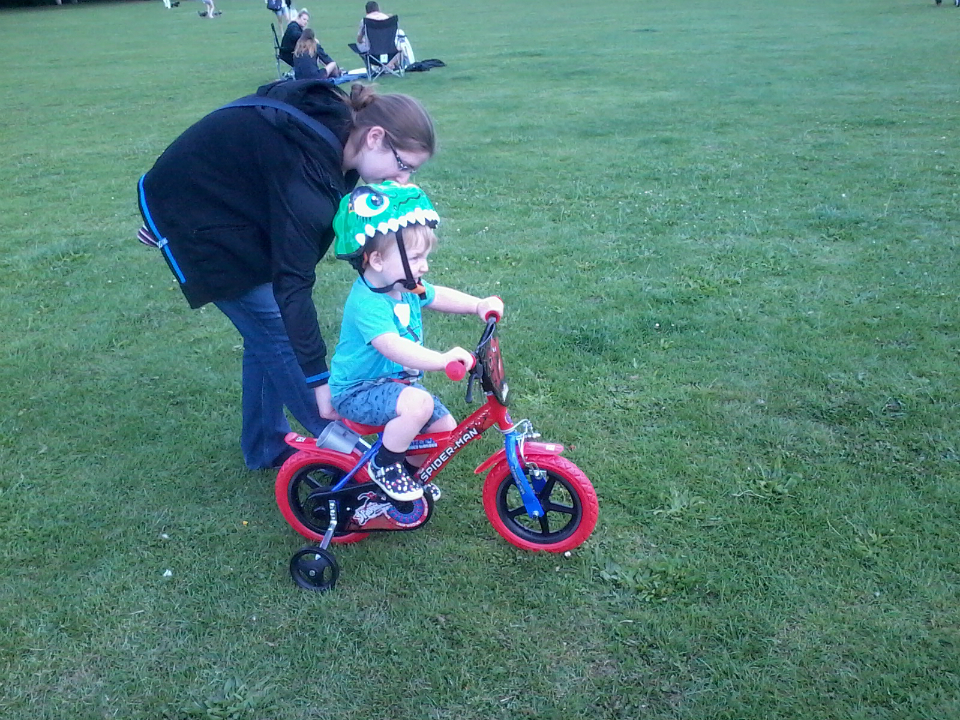 Alfie riding his bike at Kingston Fields, with a little help from Mummy!