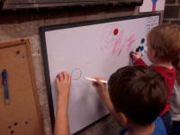 Mason and Alfie making use of the whiteboard at The Norman Tower.