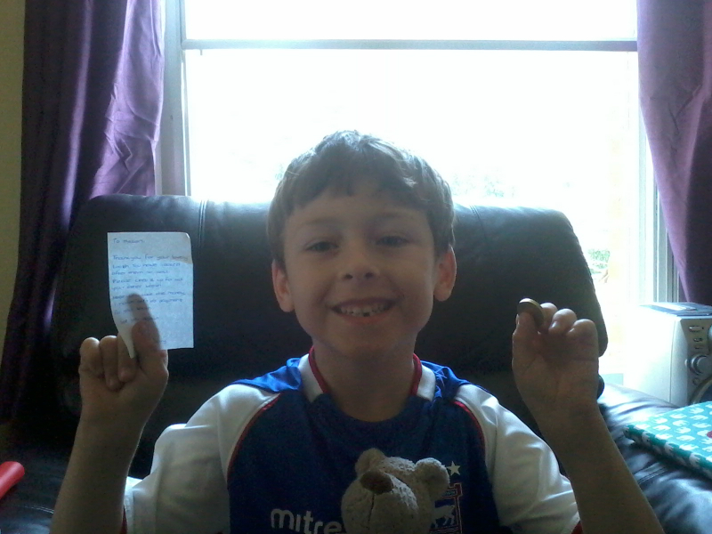 Mason showing off his gap and the note and pound coin he got from the tooth fairy!