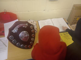The boys looking at the George W Pipe trophy and through the competition's history books.