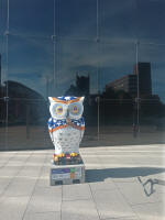 One of the owls, with the reflection of St Nicholas' church in the Willis Building behind.