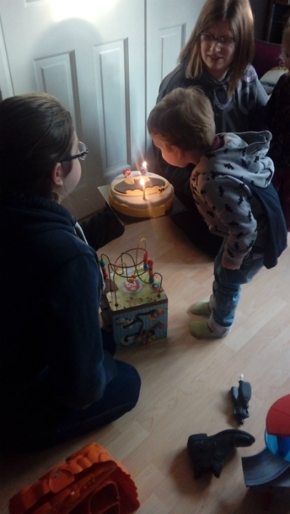 Alfie blowing out the candles on his birthday cake.