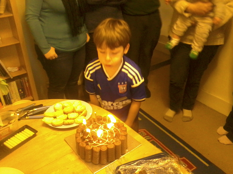 Mason blowing the candles out on his cake.