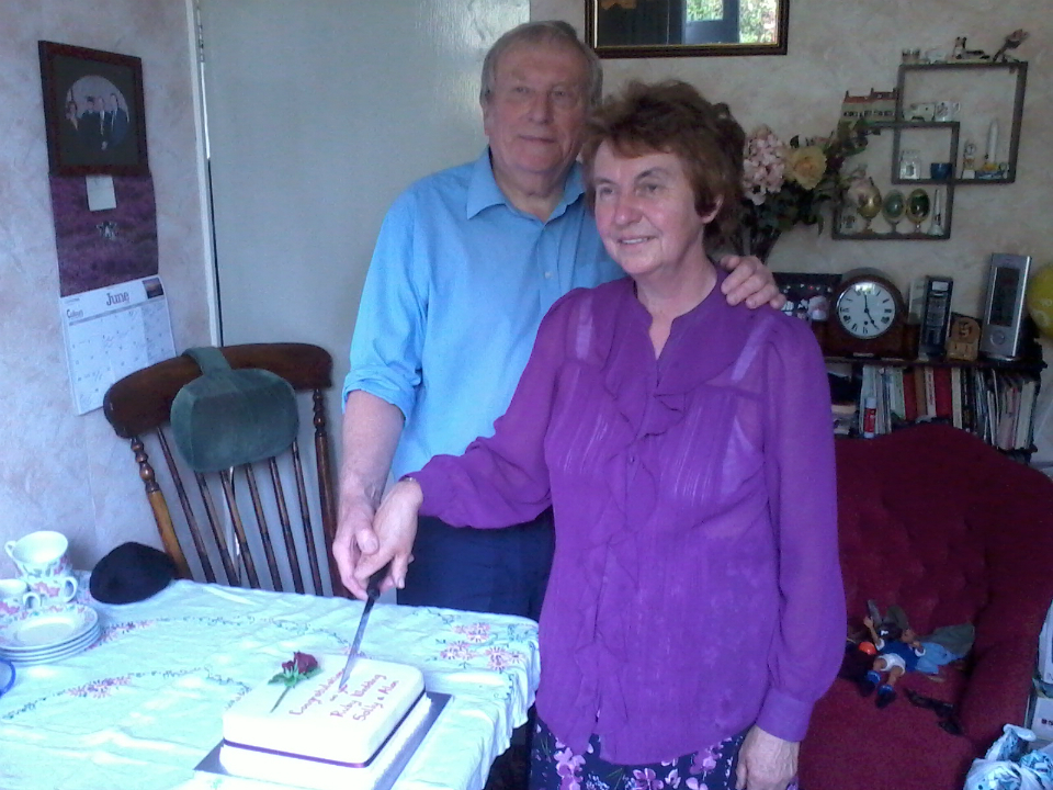 Mum and Dad cutting their cake.